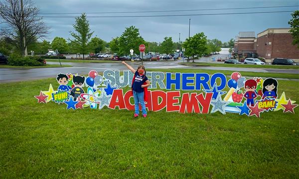 People take photo next to superhero sign